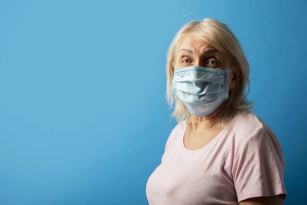 Gammal Kvinna Skyddande Medicinsk Mask Blå Isolerad Bakgrund Begreppet Coronavirus — Stockfoto