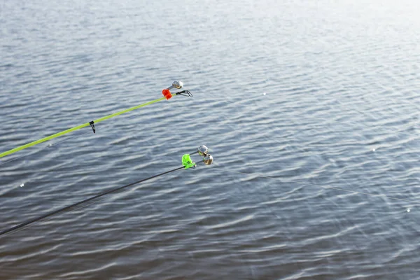 在阳光明媚的日子里 在河流或池塘的背景下钓鱼的带有铃铛的钓竿 概念钓鱼 徒步旅行 — 图库照片