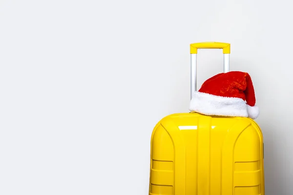 Желтом Пластиковом Чемодане Красной Шляпе Санта Клауса Светлом Фоне — стоковое фото