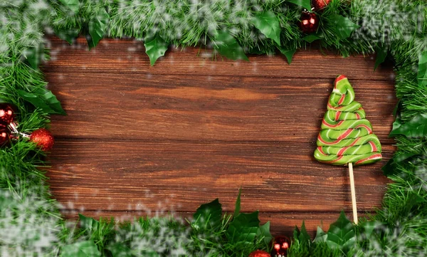 Marco de ramas de árbol de Navidad con juguetes en un fondo de madera — Foto de Stock