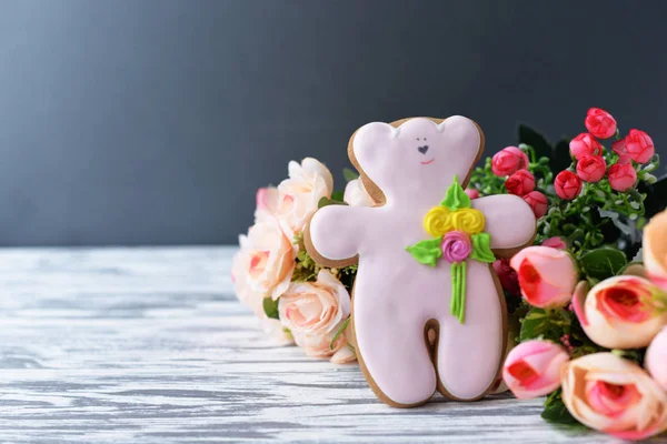 Delicious gingerbread cookie teddy bear with flowers on a wooden — Stock Photo, Image