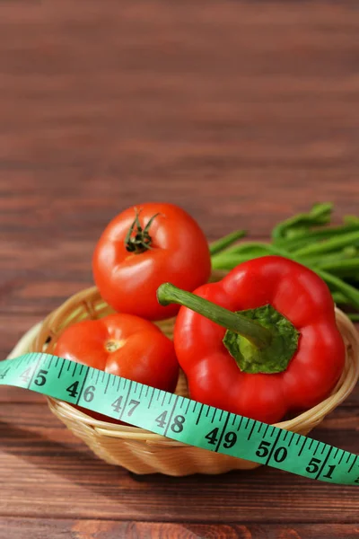 Warzywa w koszu na brązowym tle drewnianych, pomidory — Zdjęcie stockowe