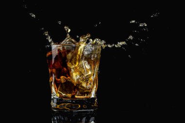 Alkol, buzlu viski, siyah bir arka planda bardakta damlalar.