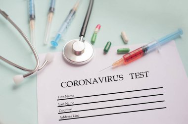 Kan testi yapılan bir şırınga ve bir stetofondoskop ile hasta anketi ve Cornovirus salgını için haplar.