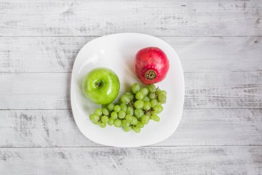 Taze elma, üzüm ve nar masanın üzerinde. Ekolojik ahşap arka plan.