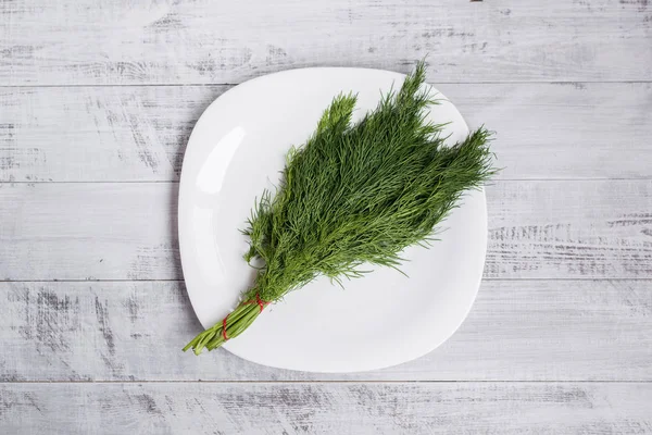 Frischer Dill auf einem Tisch im Teller. ökologischer hölzerner Hintergrund. — Stockfoto