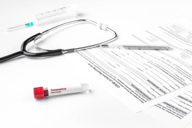 Coronavirus 2019 nCov için kan testi yapılan bir tüp. Test sonuçlarıyla birlikte hastanın formu. Stetoskop, şırınga, termometre. Covid-19 virüs salgını, salgın hastalık.