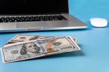 Coronavirüs salgını sırasında evden çalışma kavramı. İnsanlar uzaktan çalışıyor. Laptop ve mavi arka plandaki banknotlar. Covid 19
