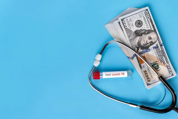 青い背景に聴診器とドル コロナウイルスの流行中の健康上のコスト 危機における医療サービスへの支払いの概念Covid 医療サービス市場の分析の概念 — ストック写真
