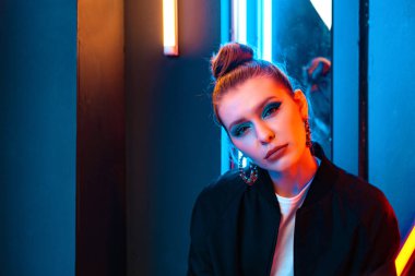 Renkli ışıklı güzel bir kızın portresi. Kırmızı ve mavi ışıklar.