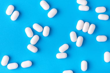 Beyaz sürahiler mavi arka planda bir yığın halinde yatar. Yakın çekim, makro fotoğrafçılık. Bir sürü nane şekeri.