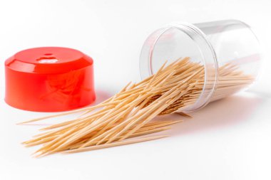 Beyaz arka planda kürdanlı bir şişe. Kürdan düşer, parçalanır, dökülür. Bir sürü dağınık kürdan..