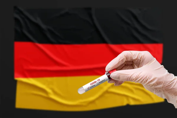 一位医生在德国国旗前拿着一个检测试管 其血液检测呈阳性 Covid 19流行病 大流行病 — 图库照片