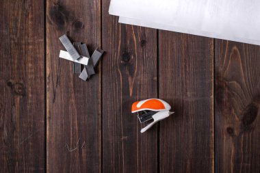 Küçük turuncu bir zımba ve tahta zemin zımbası. Yakın plan. Uzayı kopyala Metin için boşluk