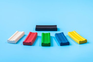 Çok renkli plastiğin parçaları mavi arka planda yatıyor..