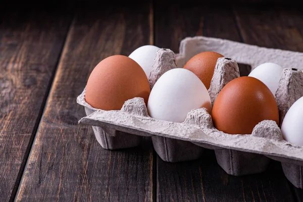 Tahta bir arka planda pakette çiğ tavuk yumurtası. Uzayı kopyala Metin için boşluk.