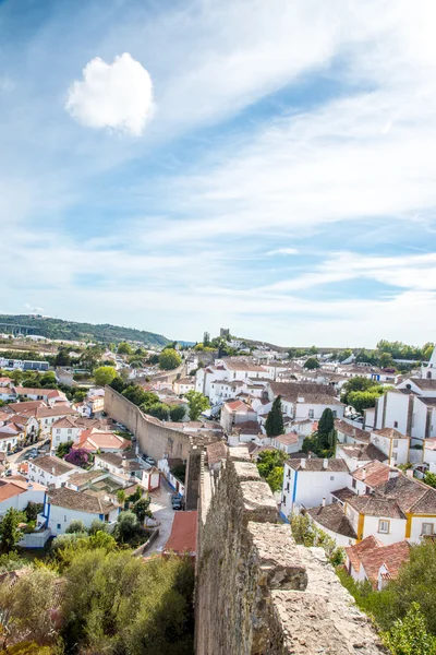 Obidos, Portugal : Cityscape of the town with medieval houses, wall and the Albarra tower. Obidos is a medieval town still inside castle walls, and very popular among tourists. — Stock Photo, Image