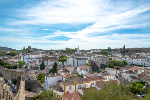 Obidos, Portugal : Cityscape of the town with medieval houses, wall and the Albarra tower. Obidos is a medieval town still inside castle walls, and very popular among tourists. — Stock Photo, Image