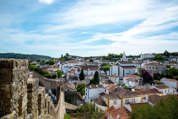 Obidos, Portugal : Cityscape of the town with medieval houses, wall and the Albarra tower. Obidos is a medieval town still inside castle walls, and very popular among tourists. — Stock Photo, Image