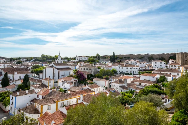 Obidos, Portugal : Cityscape of the town with medieval houses, wall and the Albarra tower. Obidos is a medieval town still inside castle walls, and very popular among tourists. — Stock Photo, Image