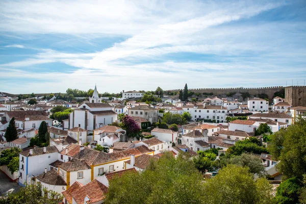 Obidos, Portugal : Cityscape of the town with medieval houses, wall and the Albarra tower. Obidos is a medieval town still inside castle walls, and very popular among tourists. — Stock Photo, Image