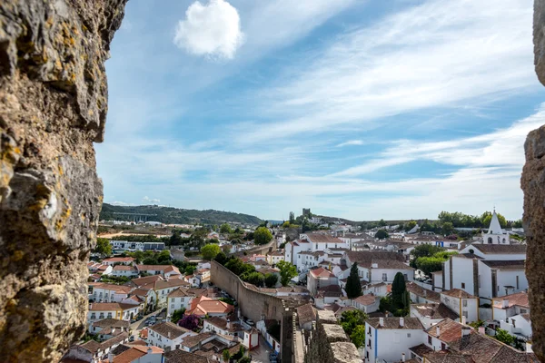 Obidos, Portugal : Cityscape of the town with medieval houses, wall and the Albarra tower. Obidos is a medieval town still inside castle walls, and very popular among tourists. — Stock Photo, Image