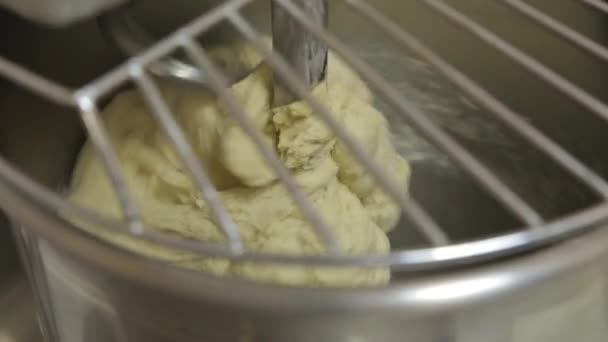 Коммерческий замеситель делает тесто, пока повар наливает муку — стоковое видео