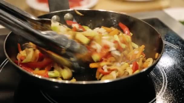 Макарони готують смажені овочі на сковороді в ресторані — стокове відео