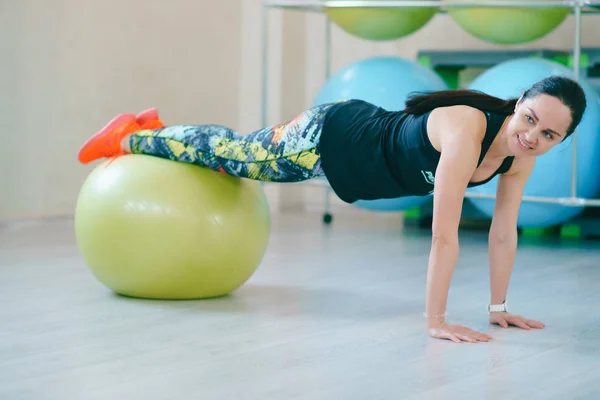 Fitness-Frau steht mit großem Ballsportgerät in der Halle — Stockfoto