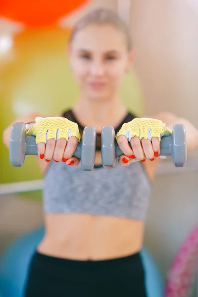 Fitness blonde woman standing with dumbbells back sport — Stock Photo, Image
