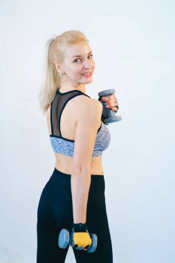 Dambıl ile geri spor duran fitness sarışın kadın