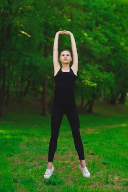 Kız parkta egzersizleri yapıyor