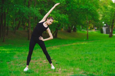 Kız parkta egzersizleri yapıyor