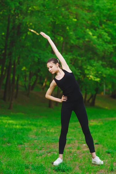 Mädchen im Park macht Übungen — Stockfoto
