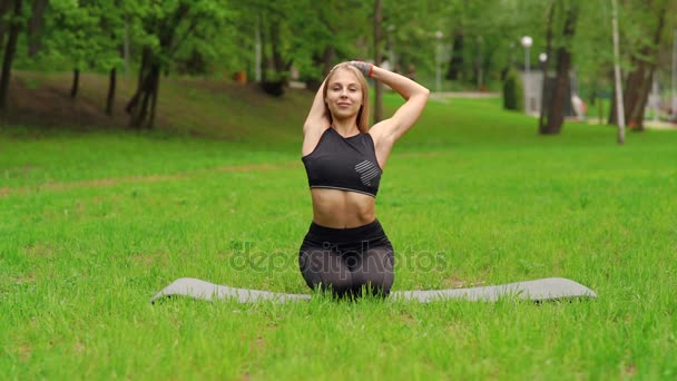 Девушка в парке занимается гимнастикой — стоковое видео