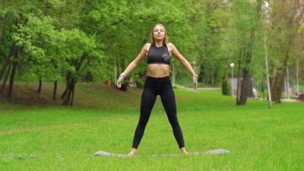 La chica en el parque se dedica a la gimnasia — Vídeo de stock