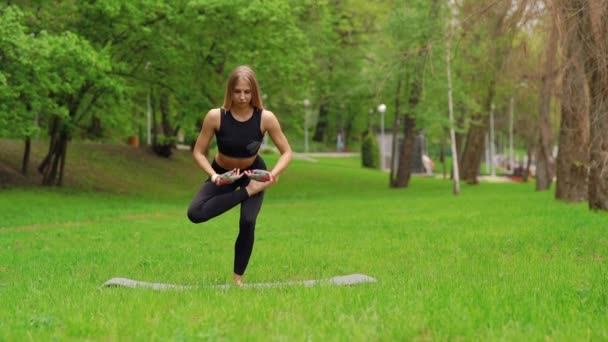 Flickan i parken är engagerad i gymnastik — Stockvideo