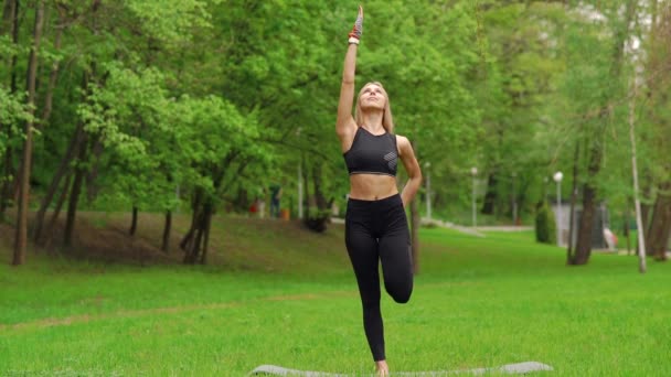 Dziewczyna w parku jest zaangażowany w gimnastyce — Wideo stockowe