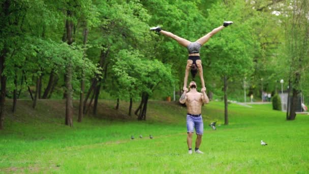 Ein Kerl und ein Mädchen treiben Sport, Luftturnen im Park — Stockvideo