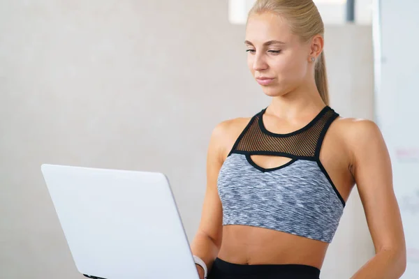 Фитнес-девушка с ноутбуком — стоковое фото