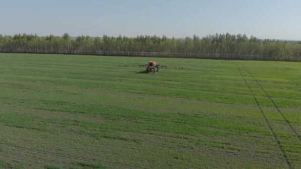 Трактор обробляє поле пестицидами та подачею листя — стокове відео