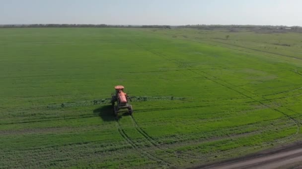Трактор обрабатывает поле пестицидами и листьями — стоковое видео