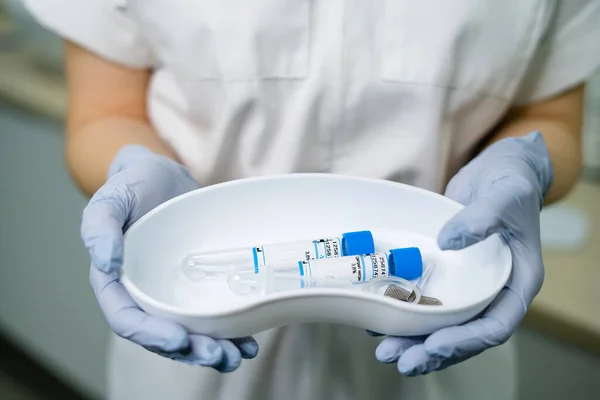 Una herramienta de recolección de tubos sostiene las manos de un médico — Foto de Stock