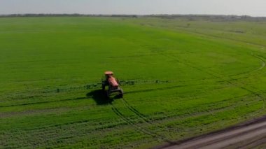 Özel kurulum ile yeşil alan irrigates traktörün havadan görünümü. Pestisitler ve kemirgenler, parazitler ve zararlıları böceklere karşı koruma ile alan büyümeleri püskürtme süreci.