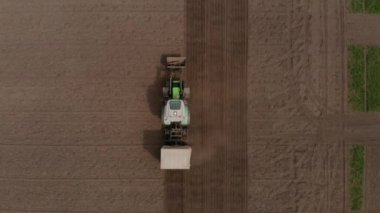 Kolza tohumu eken traktör tohumu seçim alanı baharı. Arka planda, buğday arsaları.