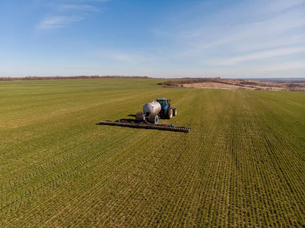 Pengenalan pupuk mineral cair ke dalam tanah dengan gandum musim dingin traktor — Stok Foto