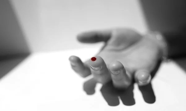A black and white finger with red blood drop — Stock Photo, Image