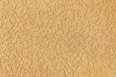 Güneşli bir günde binanın ön cephesinde bej kaplama bir yüzey. Kopya alanı ile soyut, modaya uygun, modern, doku arkaplanı.