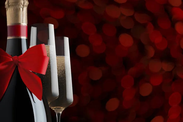 Kırmızı saten kurdeleli bir şampanya şişesi ve fotokopi alanı olan bulanık kırmızı ışıkların arka planında köpüklü şarapla dolu iki zarif bardak.