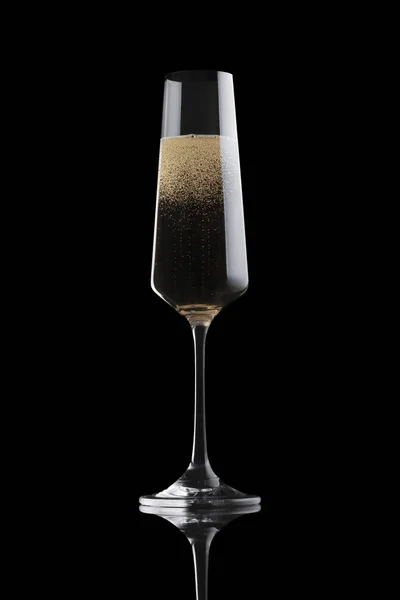 Одиночний елегантний чистий прозорий келих шампанського, наповнений ігристим вином, ізольований на чорному тлі — стокове фото